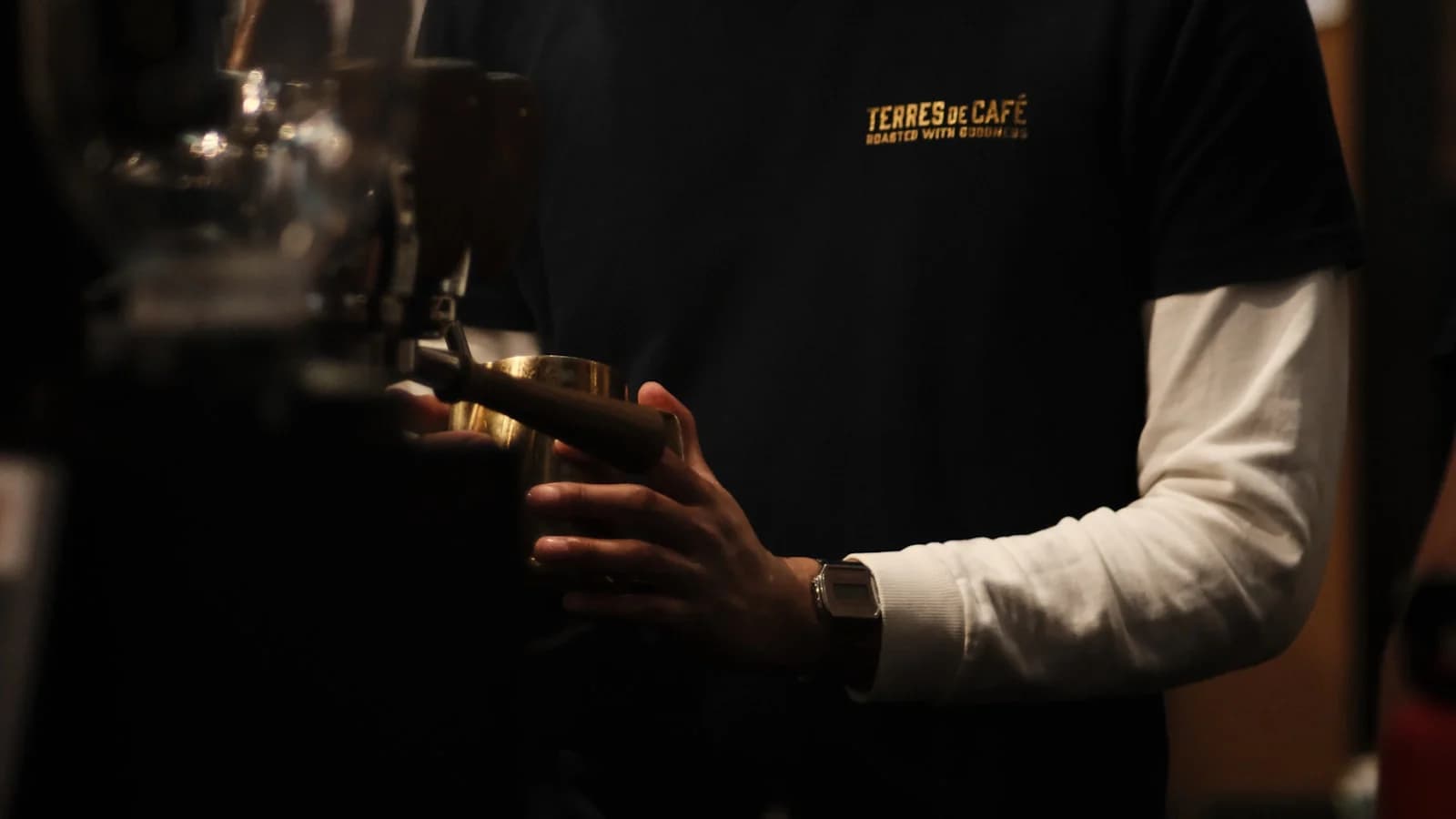 Barista preparando café en una máquina de espresso dentro de una cafetería en operación